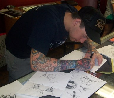 Josh prepping the stencil. The raw sketch is by his inked-up arm.